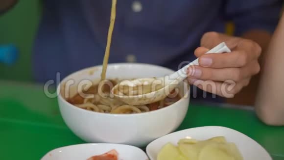 韩国餐馆里的年轻人吃传统的韩国面条视频的预览图