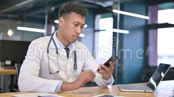 快乐的年轻医生在办公室用智能手机说话视频的预览图