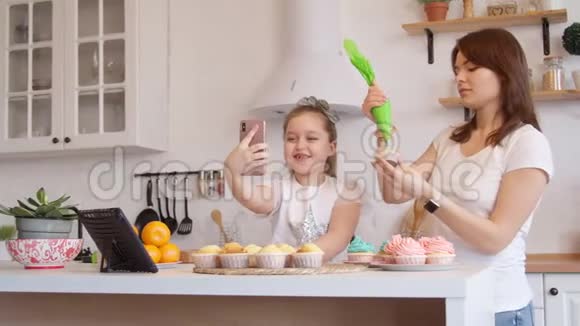 妈妈和女儿的糖衣蛋糕和视频通话视频的预览图
