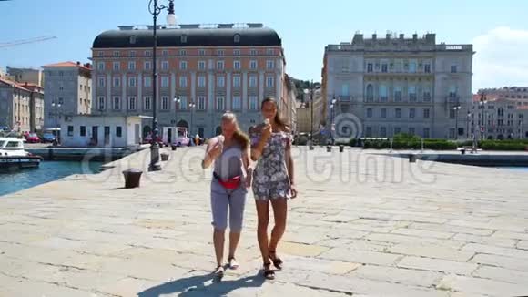 女士们享受度假在地标上吃冰淇淋视频的预览图