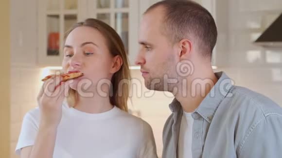 一对年轻夫妇正在客厅吃午饭吃披萨视频的预览图