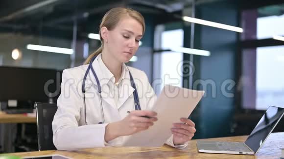 勤劳的年轻女医生在办公室阅读文件视频的预览图