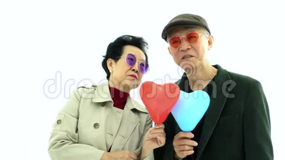 时尚时尚的亚洲老两口在空中展示心脏气球的爱视频的预览图