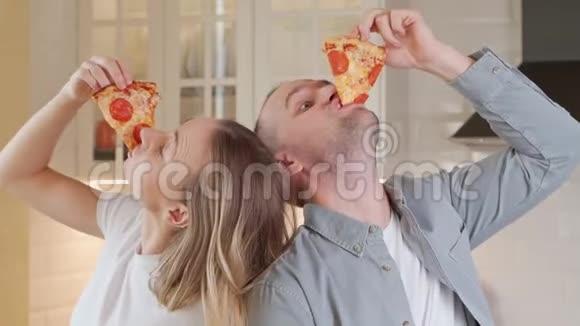 夫妻贪婪地吃着美味的披萨沉迷于快餐不健康的食物视频的预览图