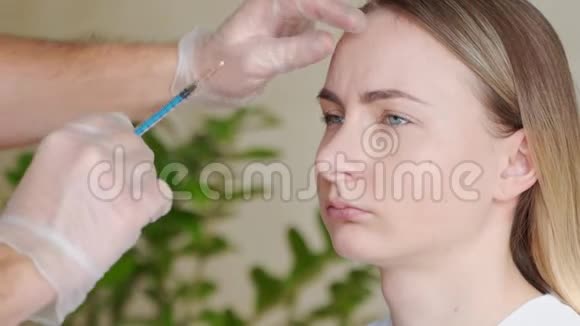 专家美容师在女性前额注射肉毒杆菌的近手视频的预览图