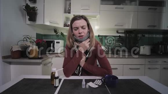 疾病的症状一个女人在坐在桌上吃药的时候会感到恶心的咳嗽温度而结冰视频的预览图