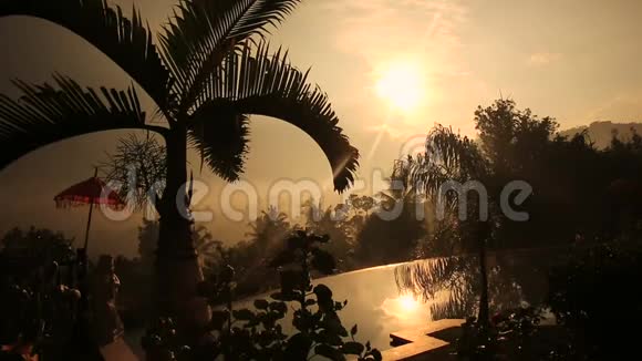 巴厘岛的传统雨伞和游泳池日落印度尼西亚视频的预览图