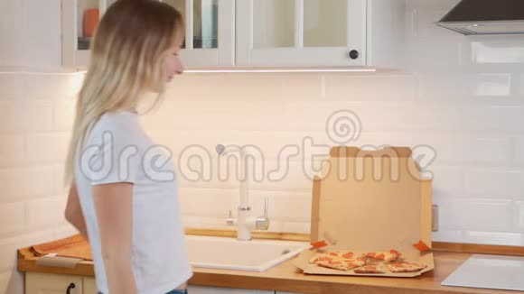 快乐的年轻女人在家吃热比萨饼视频的预览图