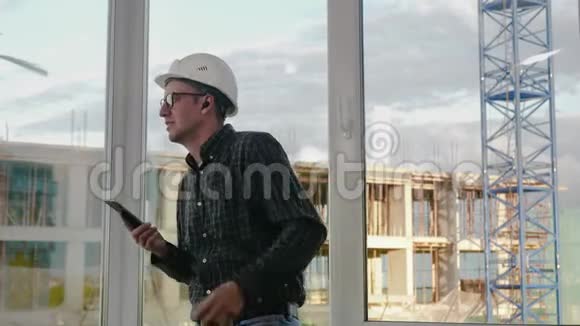 建筑工人用无线耳机听手机里的音乐视频的预览图