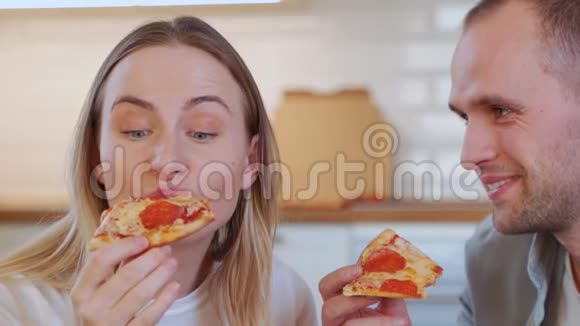 一对年轻夫妇正在客厅吃午饭吃披萨视频的预览图
