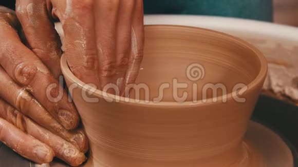 人的手在陶工轮上用粘土雕刻出一个罐子视频的预览图