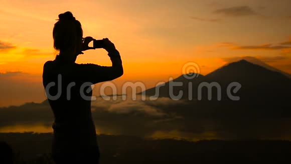 巴厘岛巴图尔湖阿贡火山和阿邦上空的女孩拍照视频的预览图