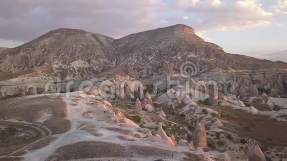 日落时卡帕多西亚一座山附近的椭圆形尖岩4k视频的预览图