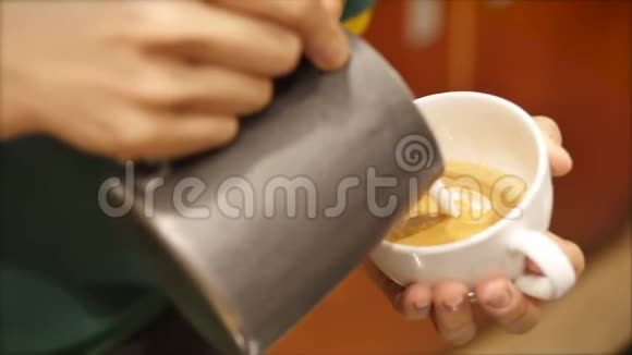 专业咖啡师制作新鲜的磨碎咖啡咖啡师制作拿铁艺术把牛奶倒入杯子同时制作视频的预览图