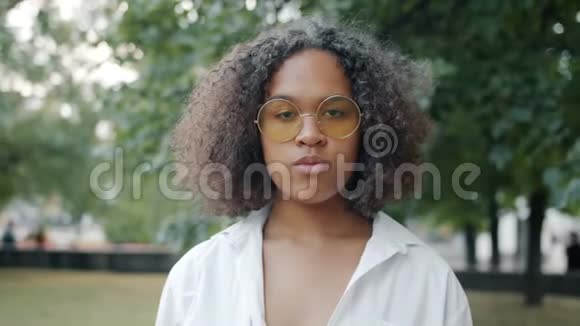 户外城市公园戴太阳镜的年轻非裔美国女士动作缓慢视频的预览图