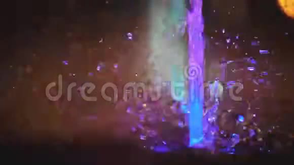 溅起五颜六色的喷泉水的缓慢运动以不同的颜色照亮落在喷泉上改变它的变化视频的预览图