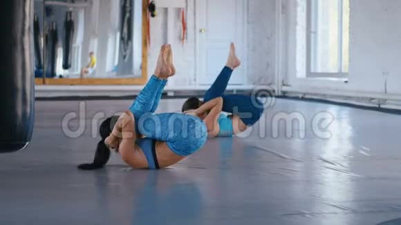 两名运动女性在健身馆锻炼腹肌女运动员正在通过做V来改善她的肌肉视频的预览图