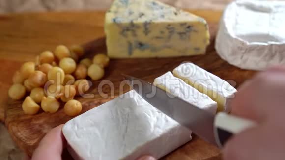 在木版上用刀切的卡蒙伯特奶酪视频的预览图