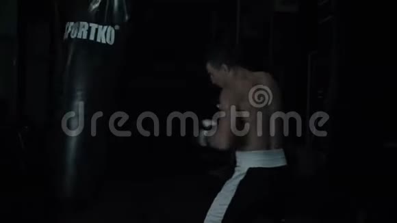 一个年轻的拳击手在地下运动扎德的训练中对一个拳击袋进行了猛烈的快速打击视频的预览图