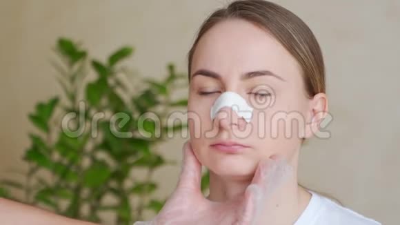 整形的概念隆鼻手术医生的手拿着女人的脸鼻子上有绷带视频的预览图