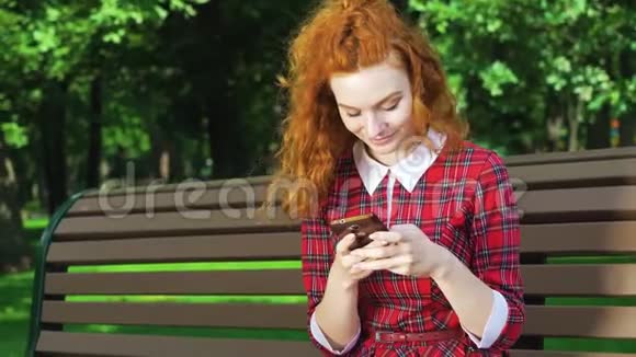 绿园智能手机上可爱的红发女孩打字信息视频的预览图