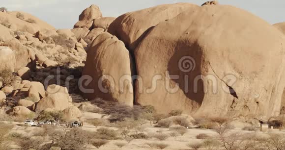 大片圆形的沙漠岩石人们在汽车附近行走纳米比亚视频的预览图