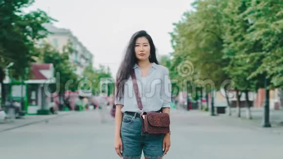 美丽的亚洲学生在城市街道上的肖像严肃的脸视频的预览图