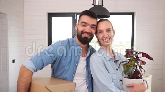 白人夫妇穿着蓝色衬衫站着在新房子里微笑视频的预览图