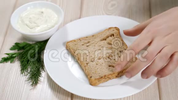 女人在麦片面包上抹豆腐视频的预览图