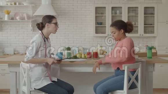 女营养学家厨房里的病人视频的预览图