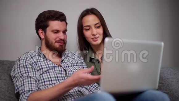 年轻的夫妇一起在笔记本电脑上看电影视频的预览图