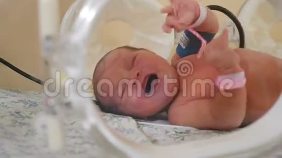 医院孵化器里生病哭泣新生儿的肖像连接新生儿腿的ICU传感器和管挽救生命视频的预览图
