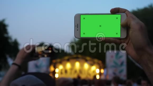 在音乐会上男人用电话录制横向视频视频的预览图