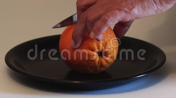 女人用手在白色背景下切橘子视频的预览图