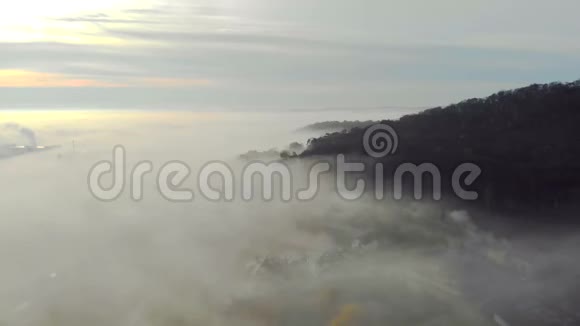 在城市的晨雾中飞翔日出和彩色的光线反射在薄雾中完美的视频的预览图