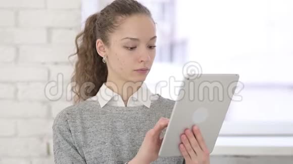 严肃的年轻拉丁女人使用平板电脑的肖像视频的预览图