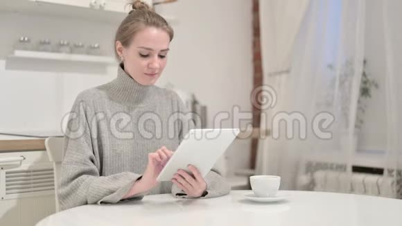勤劳的年轻女性在家里用平板电脑视频的预览图