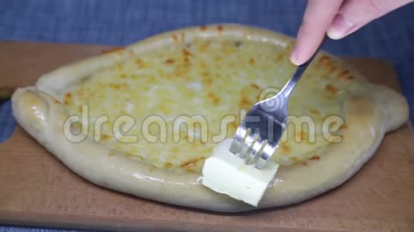 女人用叉子涂抹黄油卡查普里视频的预览图
