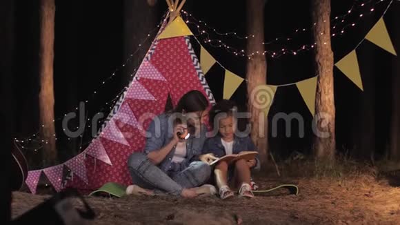 亲子关系有爱心的妈妈和美丽的女孩子一起在野餐时一起读有趣的书视频的预览图