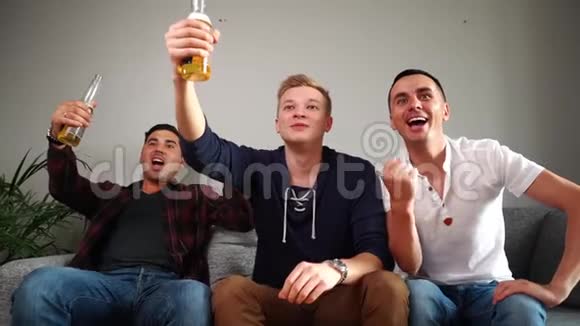 三个兴奋的朋友在家看电视上的体育比赛视频的预览图