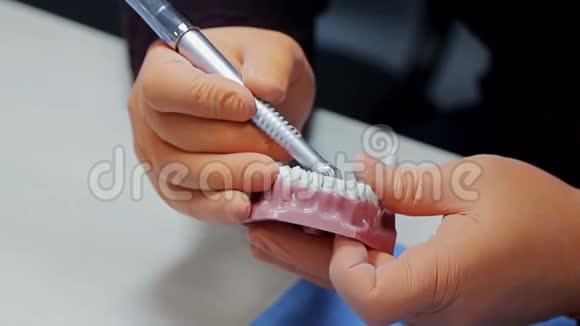 一个牙医的特写练习用钻床模拟牙齿骨架牙医熟练地练习视频的预览图
