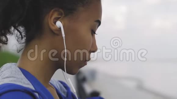 年轻的非洲裔美国女性跑步者看运动智能手表检查表现或心率脉搏跟踪视频的预览图