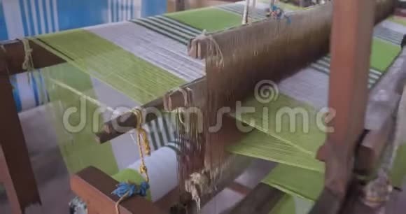 一个女人在传统的亚洲工厂里用织布机的镜头视频的预览图
