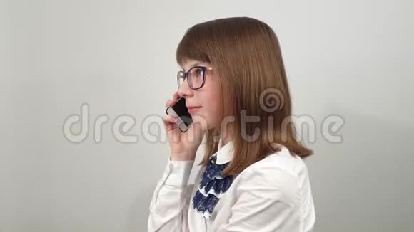 戴眼镜的女学生用手机说话视频的预览图