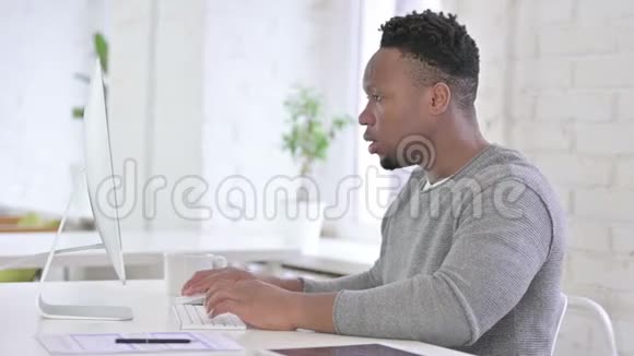 一个在桌面上工作头痛的非洲男人视频的预览图
