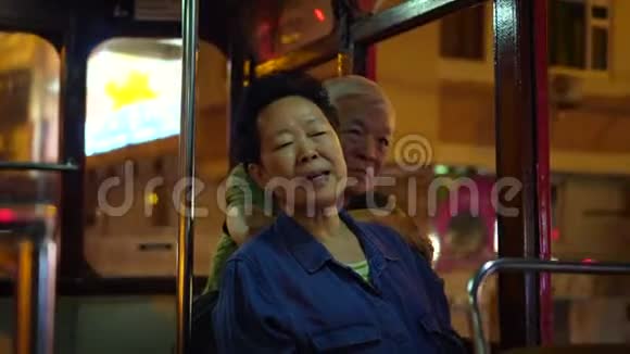 亚洲老年夫妇夜间乘坐香港城市电车畅游视频的预览图
