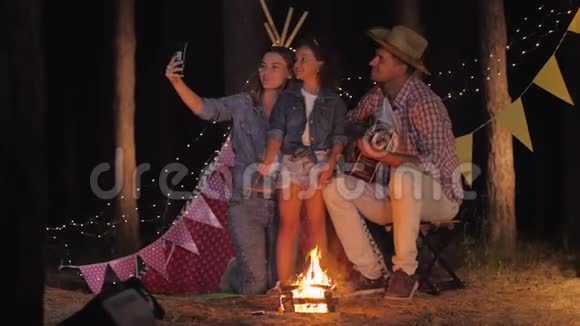 亲戚们的照片微笑着的一家人在森林里度假时用火自拍wigwam的背景视频的预览图