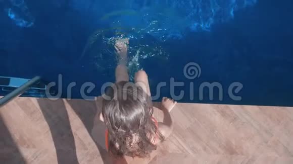 坐在游泳池附近的女孩的俯视图视频的预览图