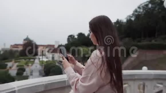 女游客在修道院用智能手机拍下小镇梅尔克的照片视频的预览图