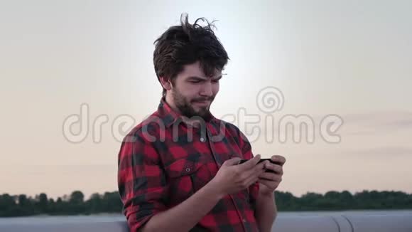 帅哥在电话里玩游戏对着镜头微笑视频的预览图